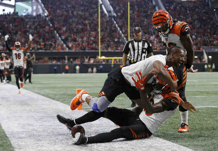 Injured running back Joe Mixon runs down the sideline and tackles wide receiver A.J. Green (18) after he catches the game-winning touchdown in the fourth quarter of the NFL Week 4 game between the Atlanta Falcons and the Cincinnati Bengals at Mercedes-Benz Stadium in Atlanta on Sunday, Sept. 30, 2018.   (Sam Greene / The Cincinnati Enquirer)